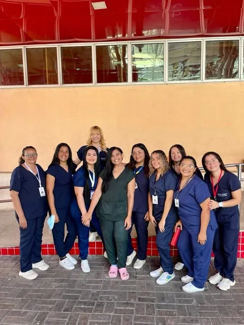 Alunas e alunos de Enfermagem do Cierpi, de jaleco e uniforme, posando no pátio